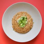 kimchi fried rice in a round bowl on red bench