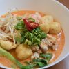 Easy laksa noodle soup in white bowl on timber benchtop